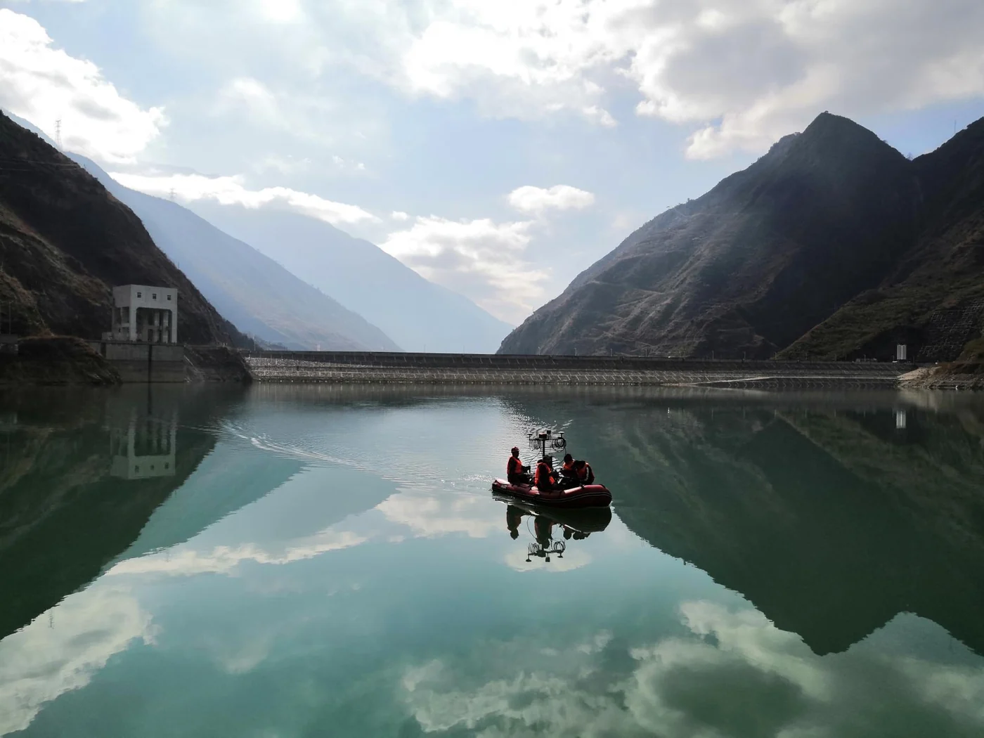 A survey vessel on a reservoir surrounded by mountains